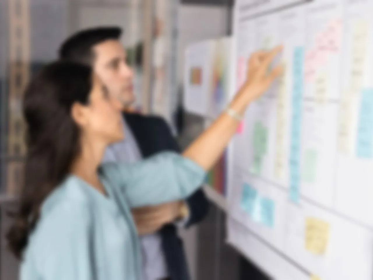 Performance-Management einführen: zwei Personen besprechen im Workshop Haftnotizen an einer Wand